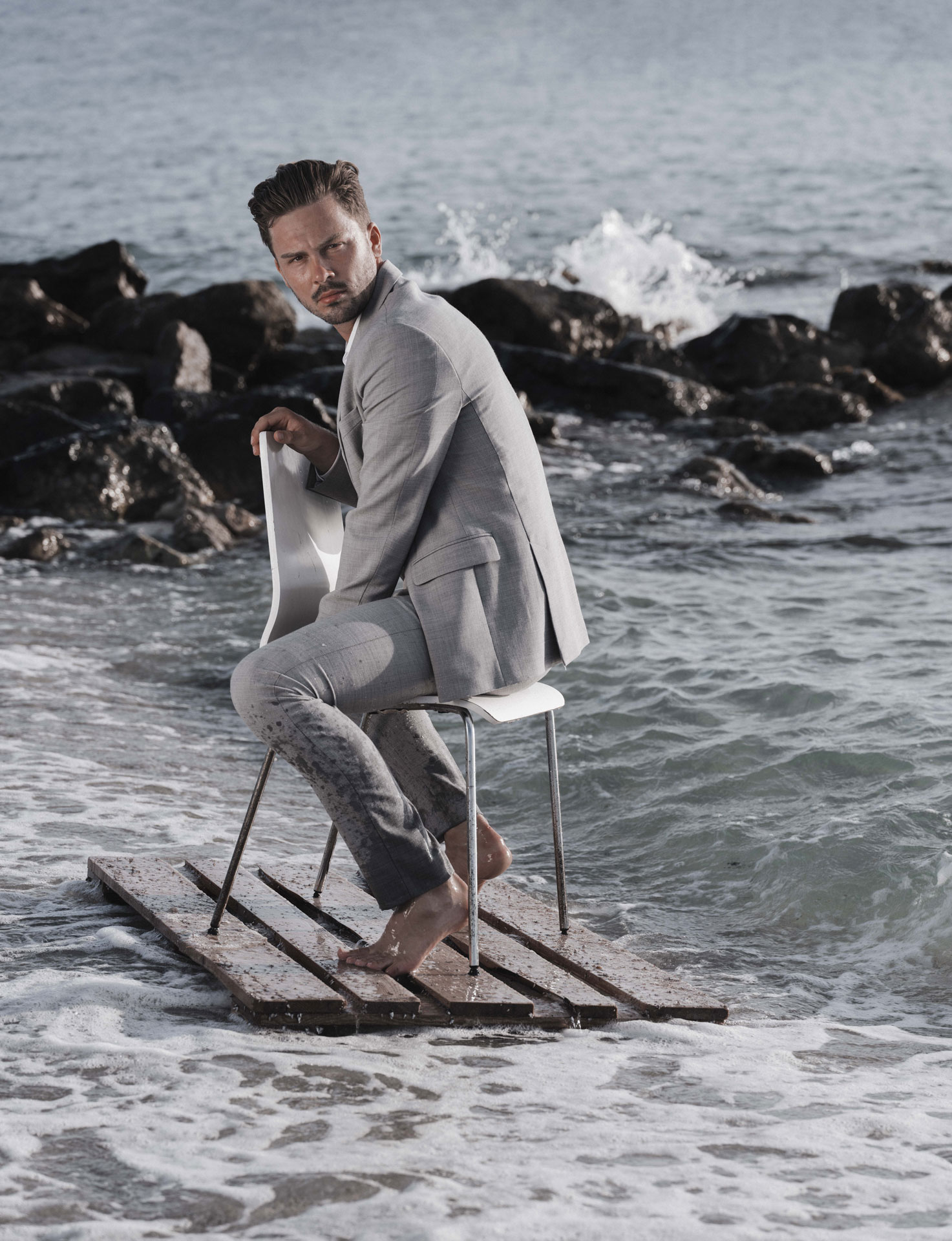 mann auf Stuhl im Wasser Fashion Shooting