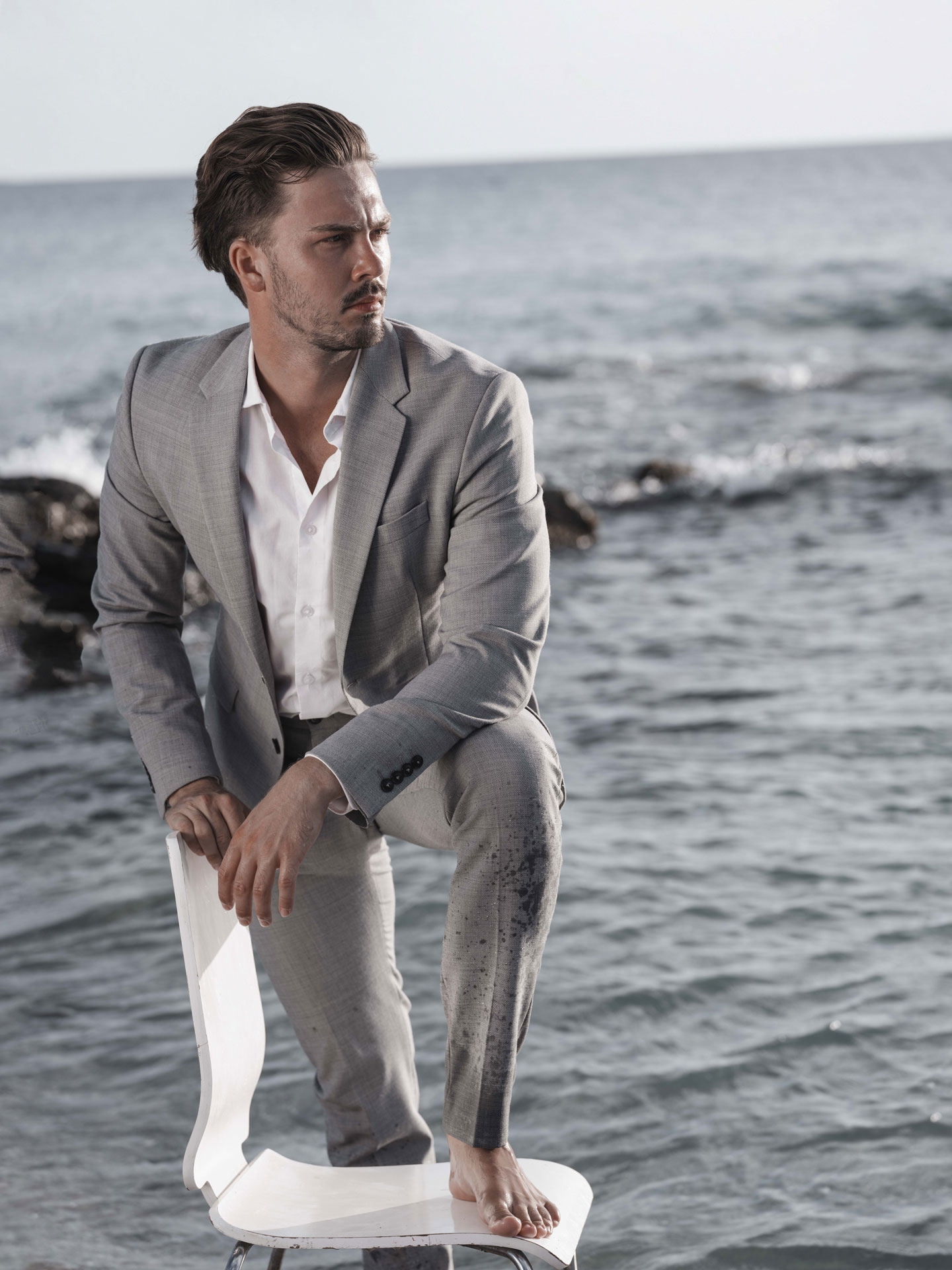 mann auf Stuhl im Wasser Fashion Shooting
