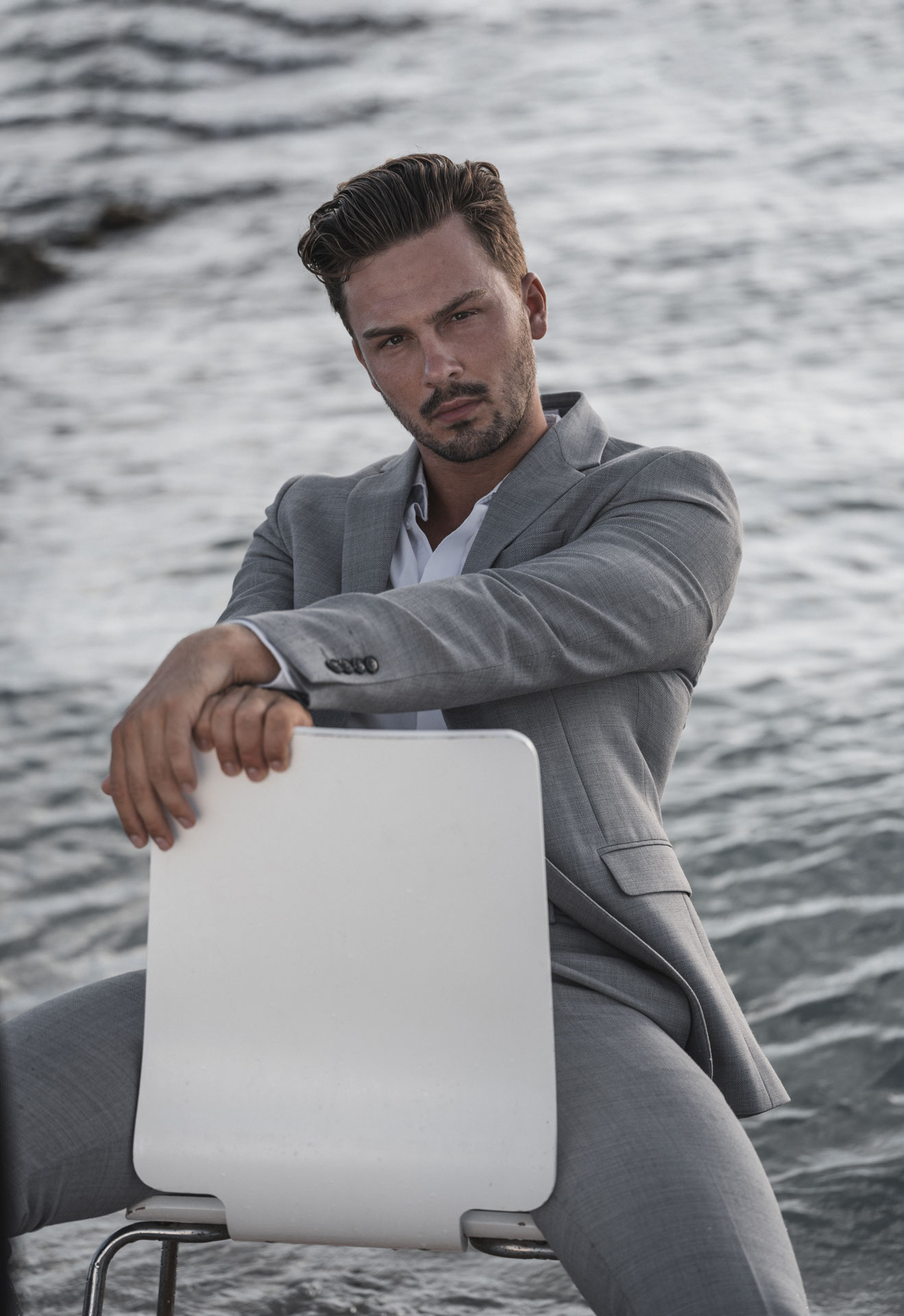 mann auf Stuhl im Wasser Fashion Shooting