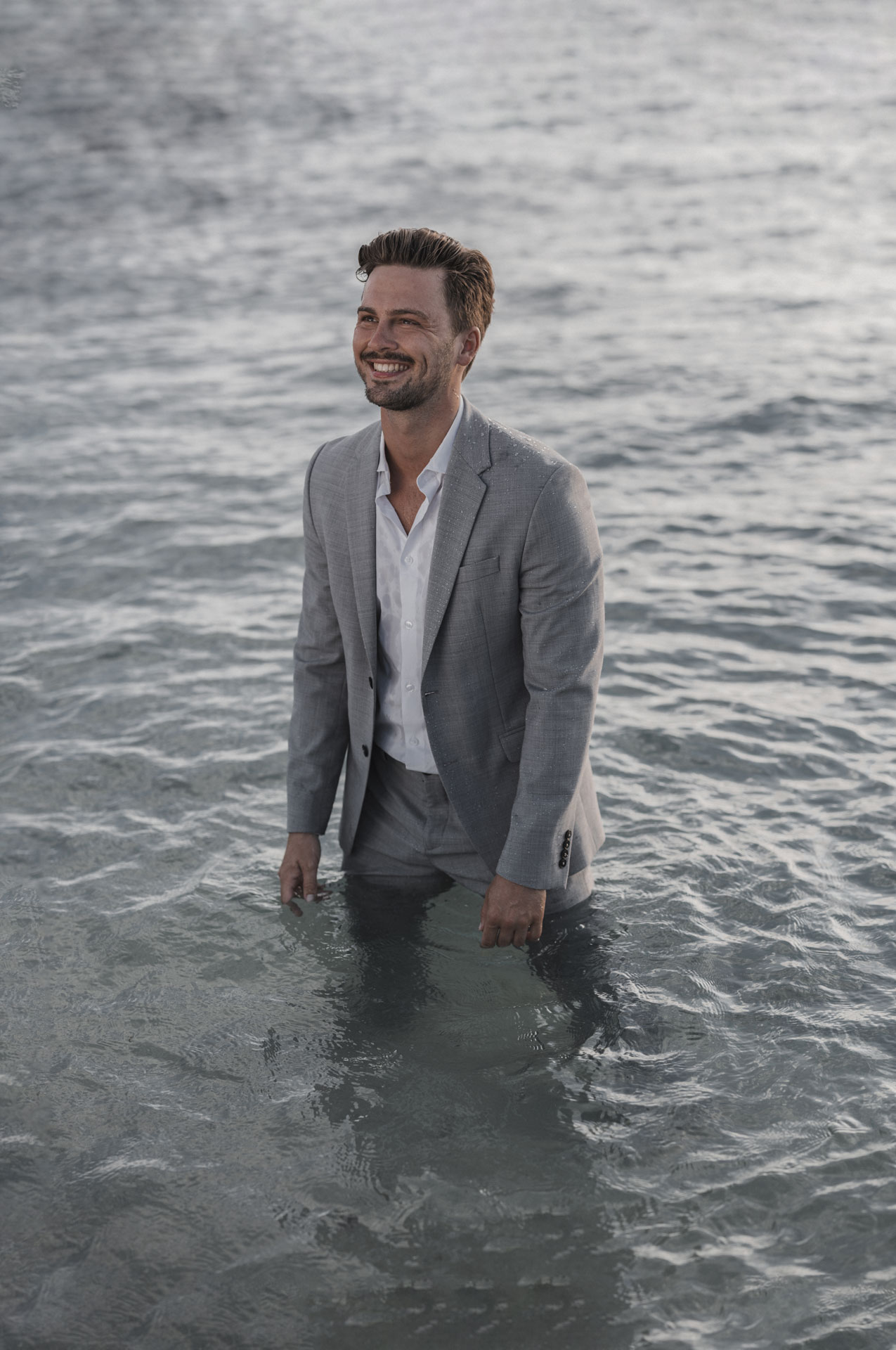 mann auf Stuhl im Wasser Fashion Shooting
